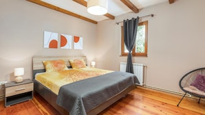 A bedroom with a wooden bed, a nightstand, a chair, and artwork on the wall. - Pet friendly home in Svetvincenat (Svetvincenat)