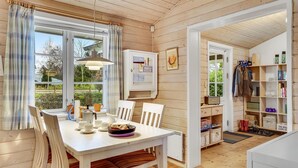 A cozy wooden interior with a dining area, a bookshelf, and a view of the outdoors. - 3 bedroom gorgeous home in Slagelse (Slagelse)