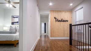 A hallway with a wooden wall and a sign that reads "The Madison." - Spacious 4BR Retreat, Sleeps 10, Backyard + Near Dallas (Dallas)