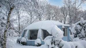 A snow-covered cabin with a single visible window and a door, surrounded by trees and bushes. - Beautiful home in Chaam with WiFi (Chaam)