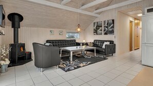 A modern living room with a fireplace, leather sofas, a coffee table, and abstract wall art. - Gorgeous home in Hejls with WiFi (Hejls)