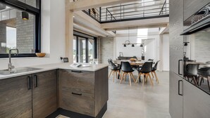 A modern kitchen with a central island, dining area with chairs, and a staircase leading to an upper level. - Gorgeous home in Skjern with kitchen (Skjern)