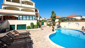 A two-story building with a swimming pool, outdoor seating, and a dolphin mural. - Stunning apartment in Vodice with WiFi (Vodice)
