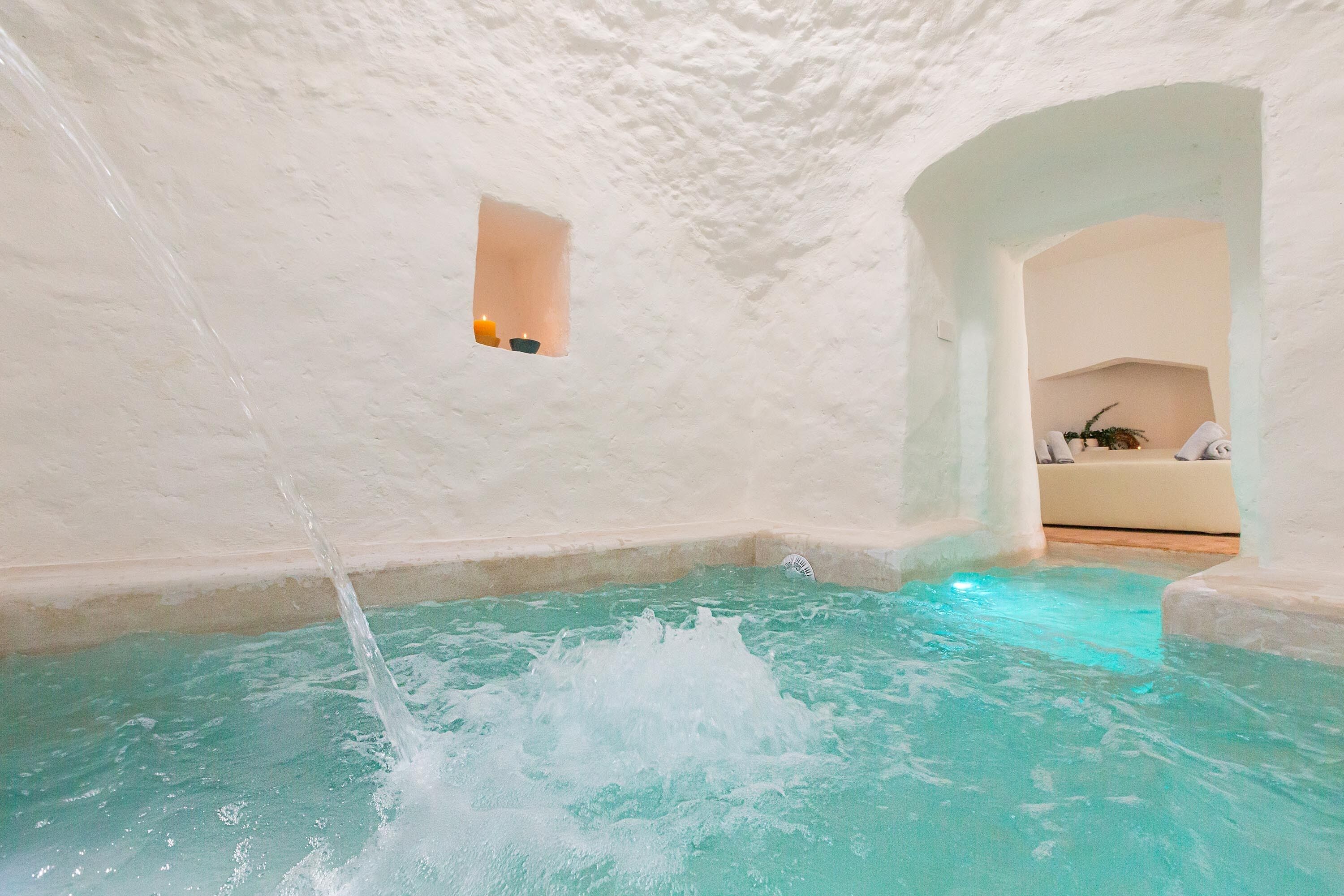 A spa area with a pool and a small window.