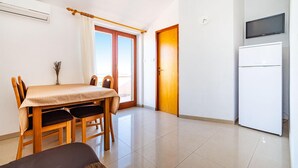 A compact living space with a dining area, a kitchen, and a door leading to an outdoor balcony. - Nice apartment in Nevidane with house sea view (Nevidane)