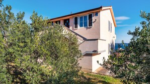 A two-story house with a sloped roof, surrounded by olive trees. - Nice apartment in Nevidane with house sea view (Nevidane)