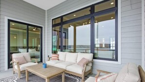 A covered outdoor seating area with a sofa, chairs, and a table.