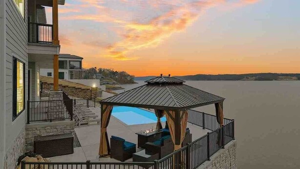 A waterfront property with a gazebo, outdoor seating, and a view of the water.