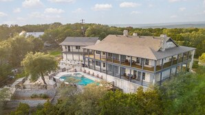 A large, multi-story house with a swimming pool and a view of the surrounding landscape. - Pet-Friendly! Pool/Spa, Views, Arcade, EV Charger (Wimberley)