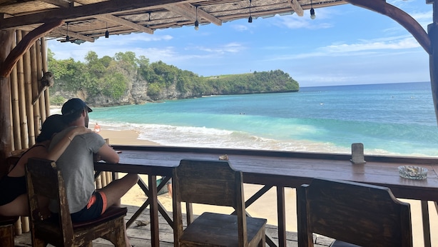 A wooden structure with a thatched roof overlooking a beach. - Santai Warung Bali (Pecatu)