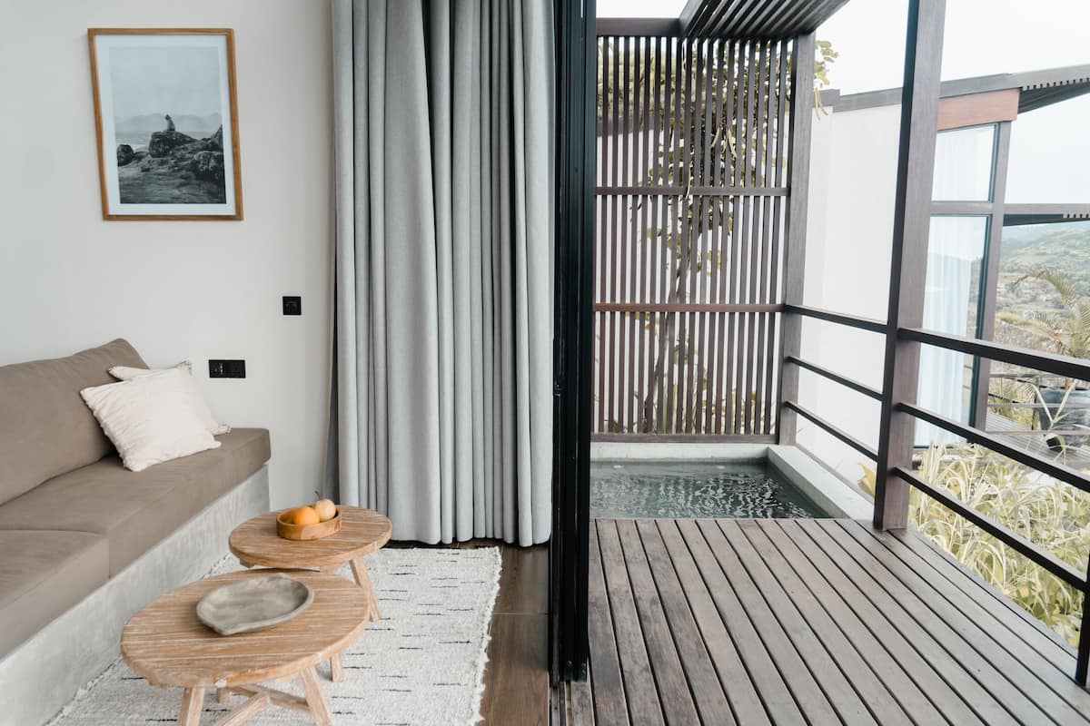 Ein modernes Wohnzimmer mit einer Couch, einem kleinen Holztisch mit einer Obstschale und einem gerahmten Bild an der Wand.