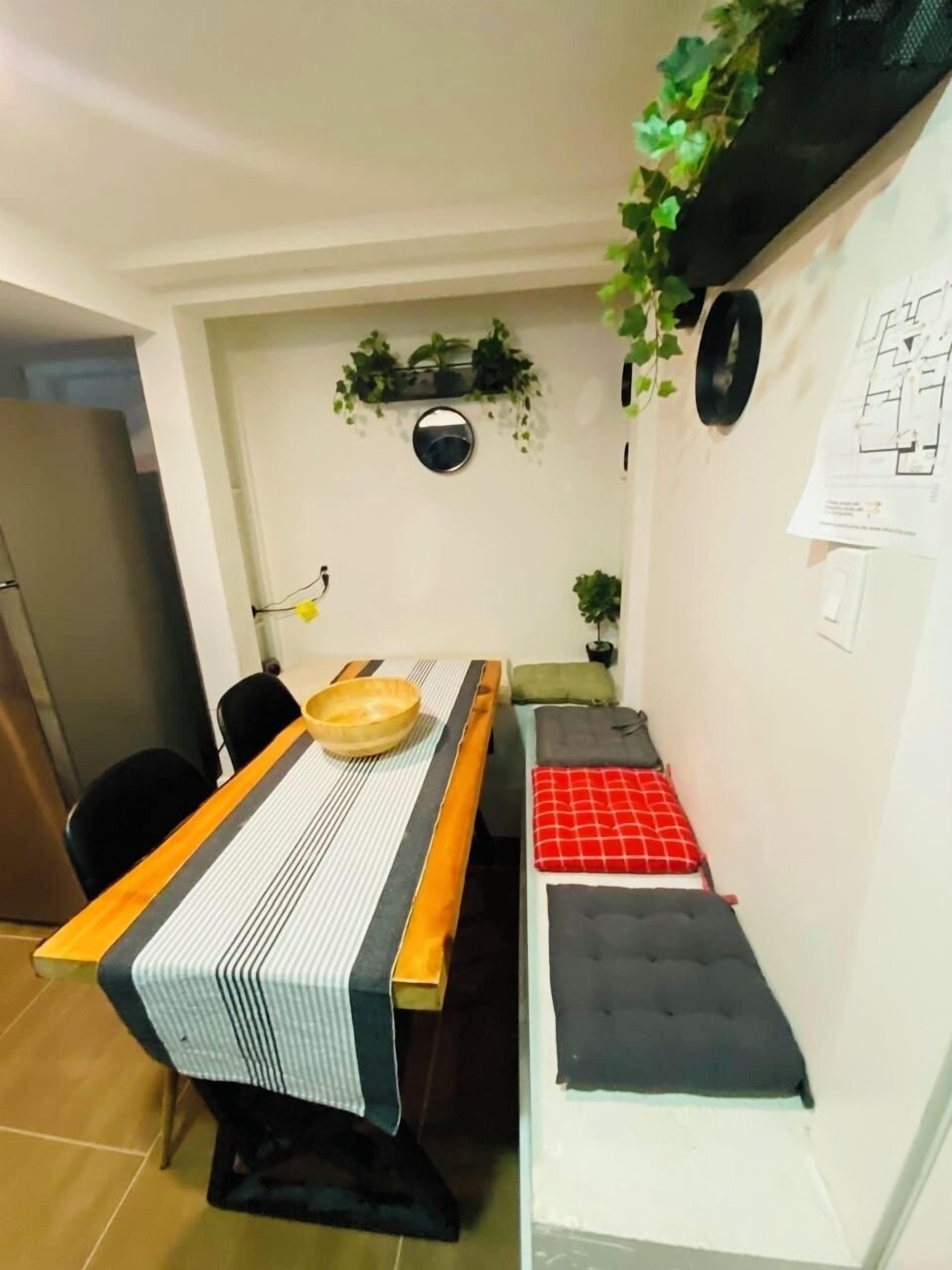 Un espacio habitable compacto con una mesa de comedor, una banca y una cama pequeña.