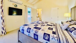A bedroom with a bed, a TV, an air conditioner, and a door.