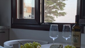 Une table avec une bouteille de vin, deux verres, du fromage et des raisins.