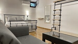 Une chambre à coucher moderne avec un lit, un téléviseur fixé au mur, un miroir et une étagère en bois.