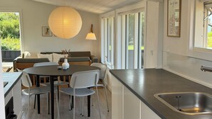 Une cuisine moderne dotée d’un îlot central, de meubles blancs et d’un évier en acier inoxydable.