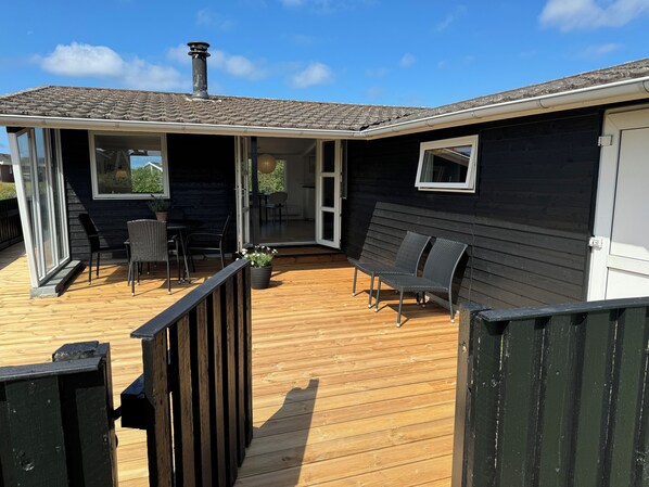 Une terrasse dotée de mobilier d’extérieur, d’une porte-fenêtre coulissante et d’une cheminée.