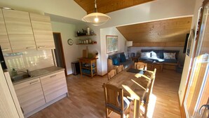 Eine geräumige Küche mit Holzausstattung und einem Essbereich mit Holztisch und -stühlen.