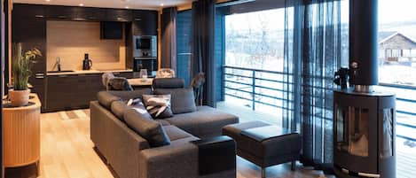 A modern living room with a sofa, a glass coffee table, and a fireplace.