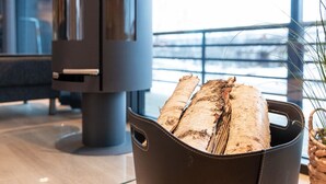 A modern interior with a fireplace and a bucket of firewood. - Saanan lumous by Interhome (Enontekiö)