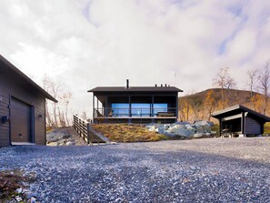 A modern house with a large windowed porch, a garage, and a small shed. - Saanan lumous by Interhome (Enontekiö)