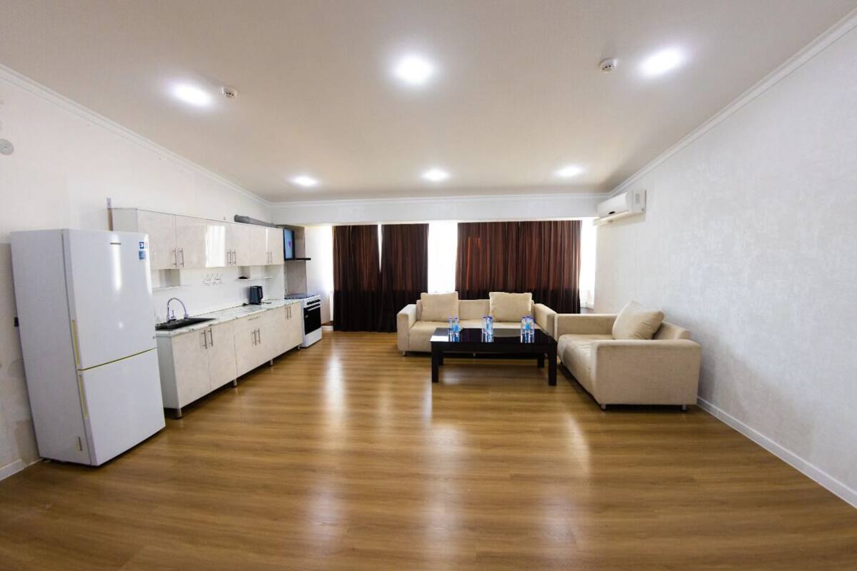 A spacious living area with a kitchen, a sofa, and a coffee table.