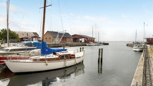 A marina with boats docked, wooden buildings, and a calm water body. - Lovely home in Fejø with WiFi (Fejø)