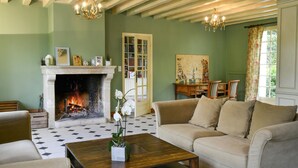 A living room with a fireplace, a sofa, a coffee table, and a bookshelf. - Lovely home in Yèvre-la-Ville (Yèvre-la-Ville)