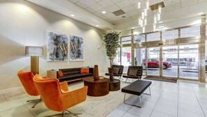 A modern lobby with a sofa, chairs, a coffee table, and artwork on the walls.