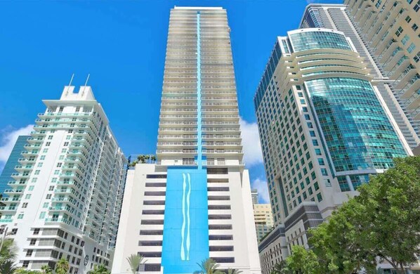 A tall, modern skyscraper with a distinctive blue vertical stripe.