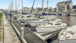 A marina with multiple boats docked, a pedestrian walkway, and buildings in the background. - Nice apartment in Redon with WiFi (Redon)