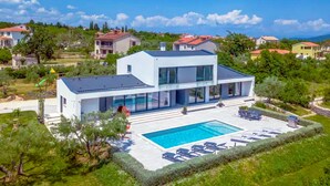 A modern two-story house with a swimming pool and outdoor seating. - Awesome home in Rakalj (Rakalj)
