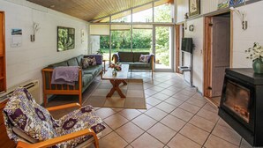 Ein gemütliches Wohnzimmer mit Sofa, Sesseln und Kamin.