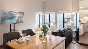 Un coin repas avec une table en bois, des chaises, des bougies et un vase rempli de fleurs.