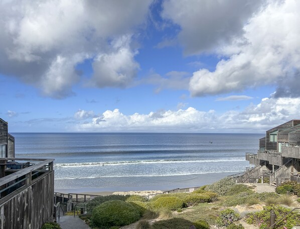 A coastal view with a wooden building overlooking the ocean. - 3870 Sand Castle - Ocean Front, Pools, Hot Tubs (Monterey)