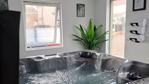 A spa room with a hot tub, a window with a view, and a potted plant. - Family Stay | Home from Home | Hot-Tub | Pets Free (BISPHAM)