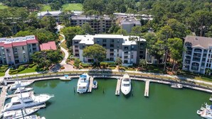 A marina with several boats docked, surrounded by multi-story buildings with balconies. - Spacious Villa, Near Shops & Beach in Harbour Town (Hilton Head Island)