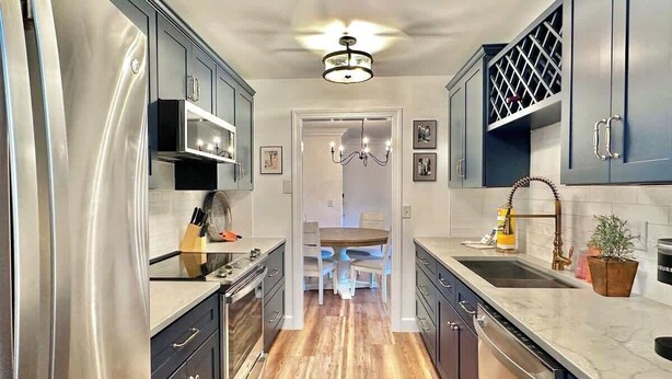 A modern kitchen with stainless steel appliances, wooden flooring, and a central island. - Spacious Villa, Near Shops & Beach in Harbour Town (Hilton Head Island)