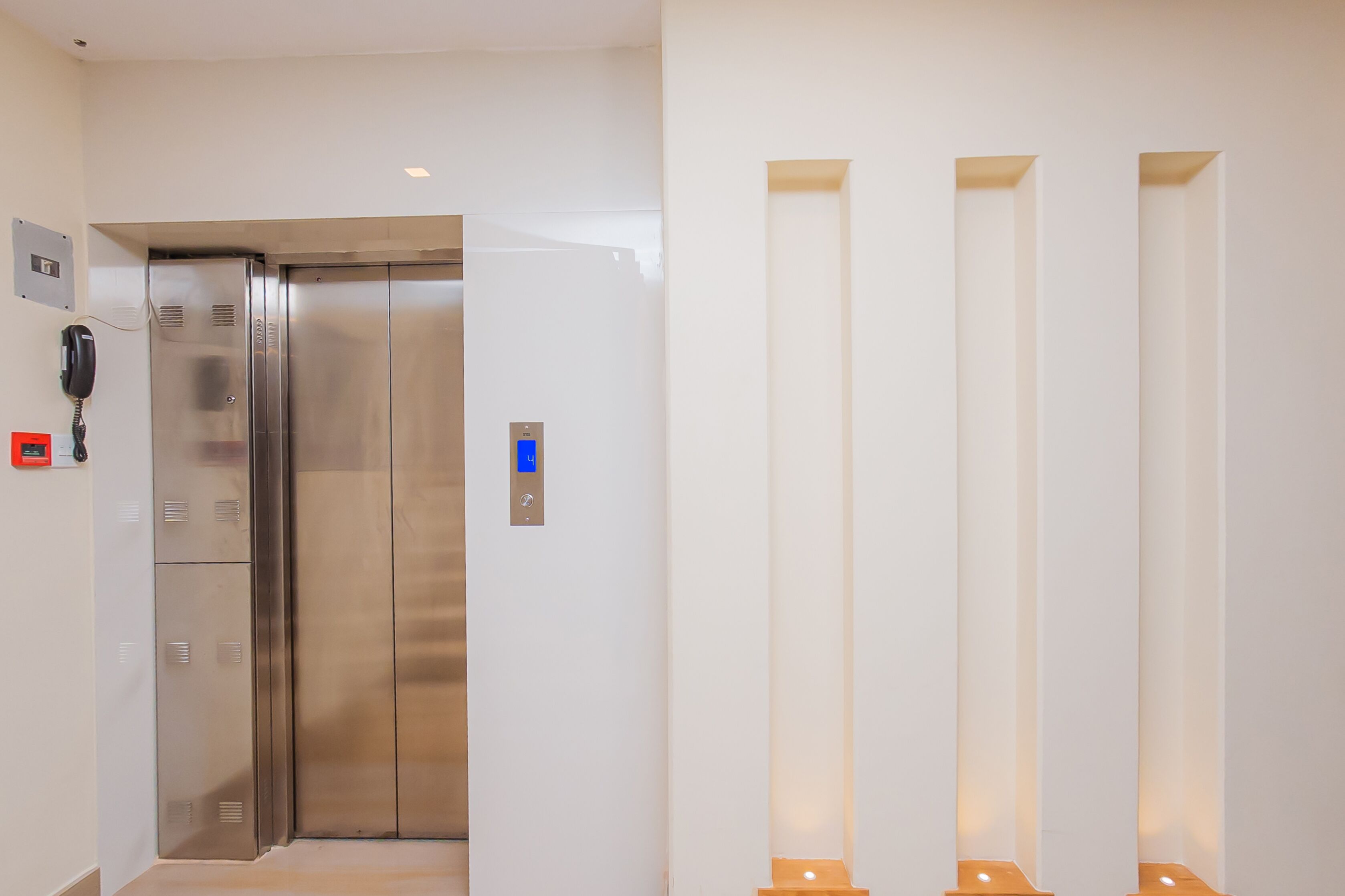 A modern elevator with a metallic finish and a digital display.