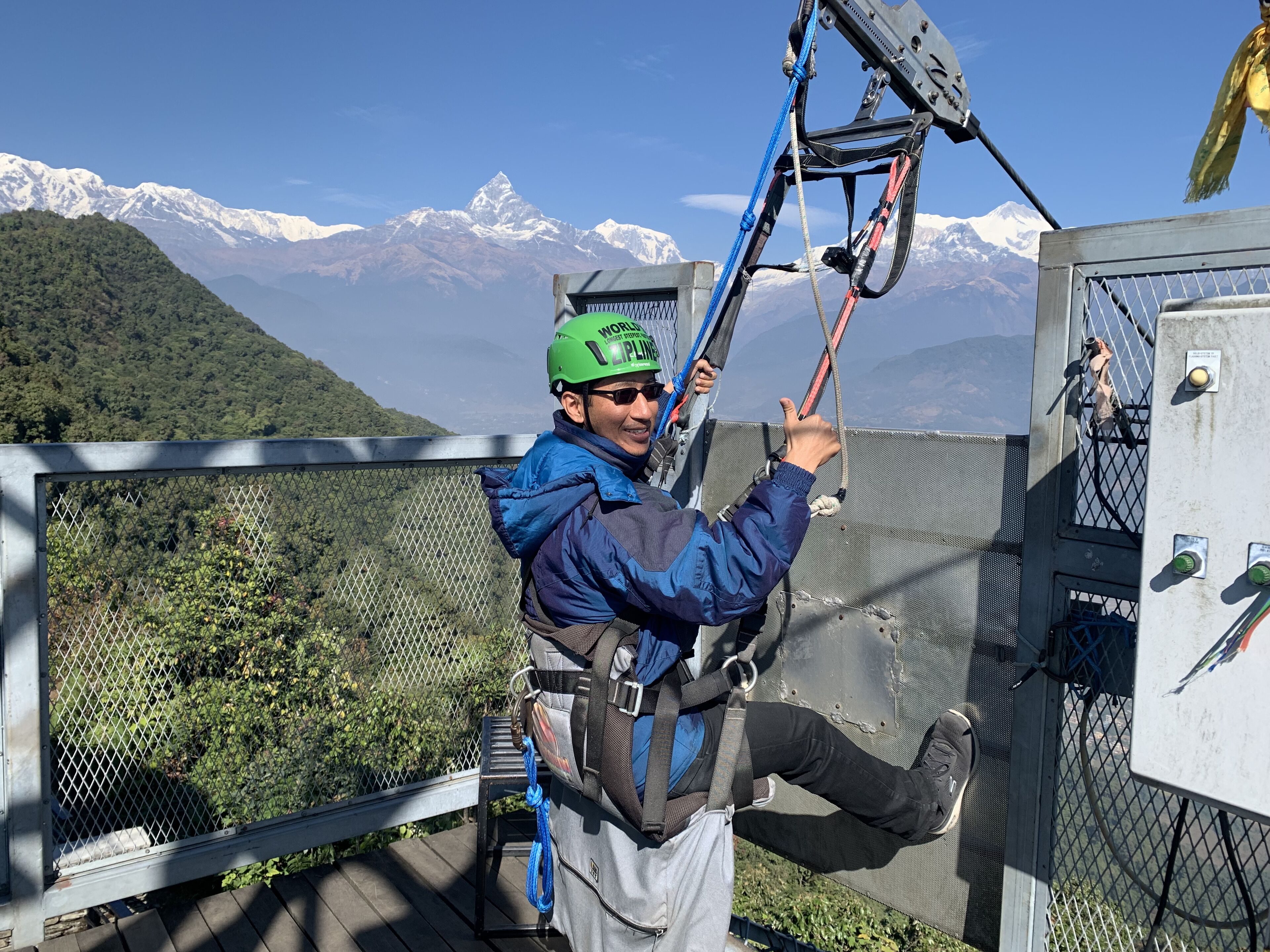Una persona en un tirolina con un paisaje montañoso de fondo.