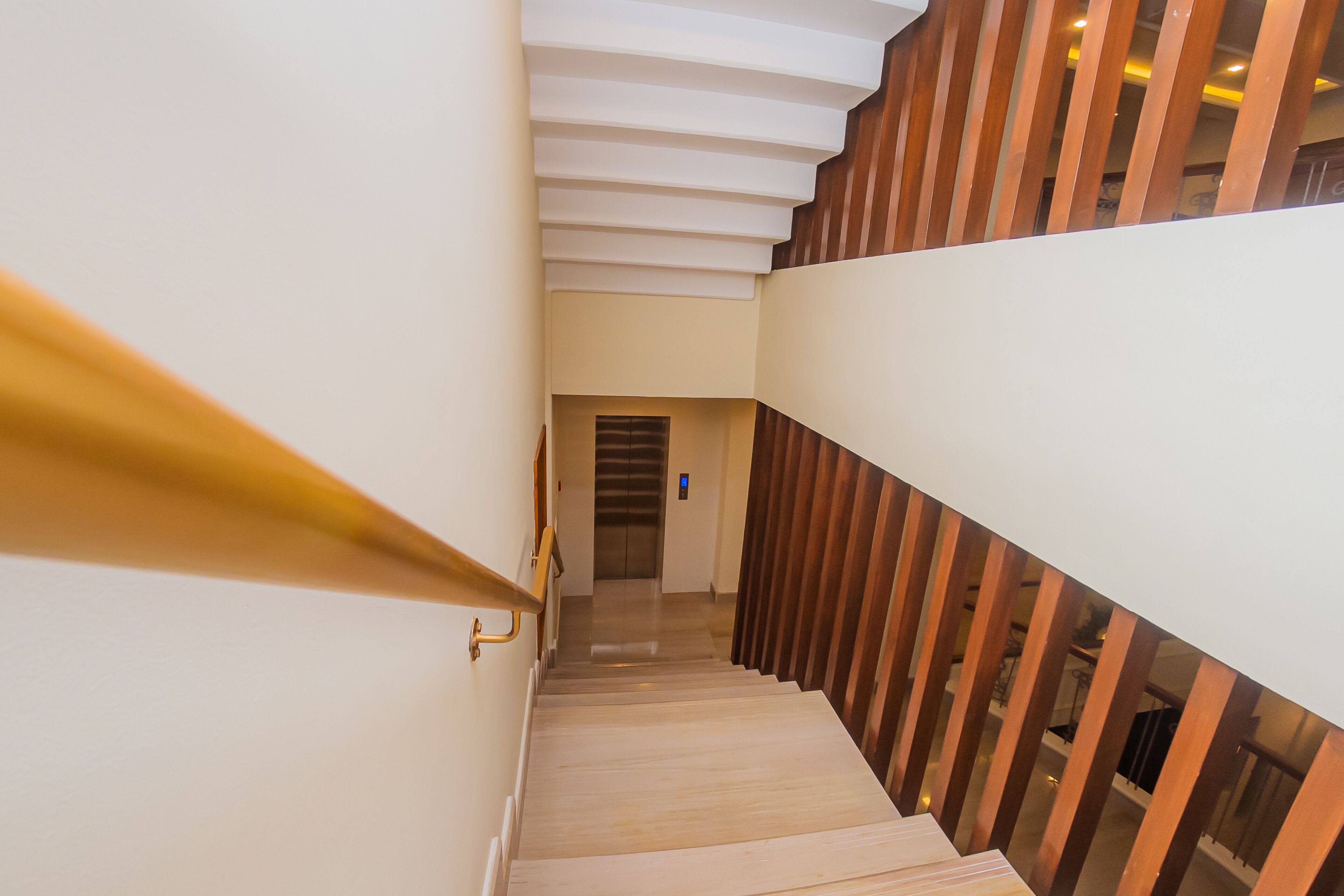 A modern staircase with wooden steps and a glass railing.