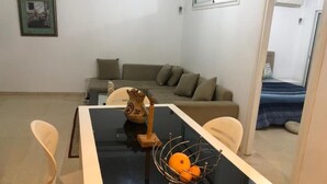 Un salon moderne comprenant une table à manger, un canapé et un petit lit.