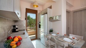 Una cocina moderna con comedor, una cafetera y un frutero.
