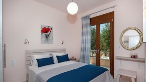 Un dormitorio con cama, mesita de noche, espejo y vistas al exterior.