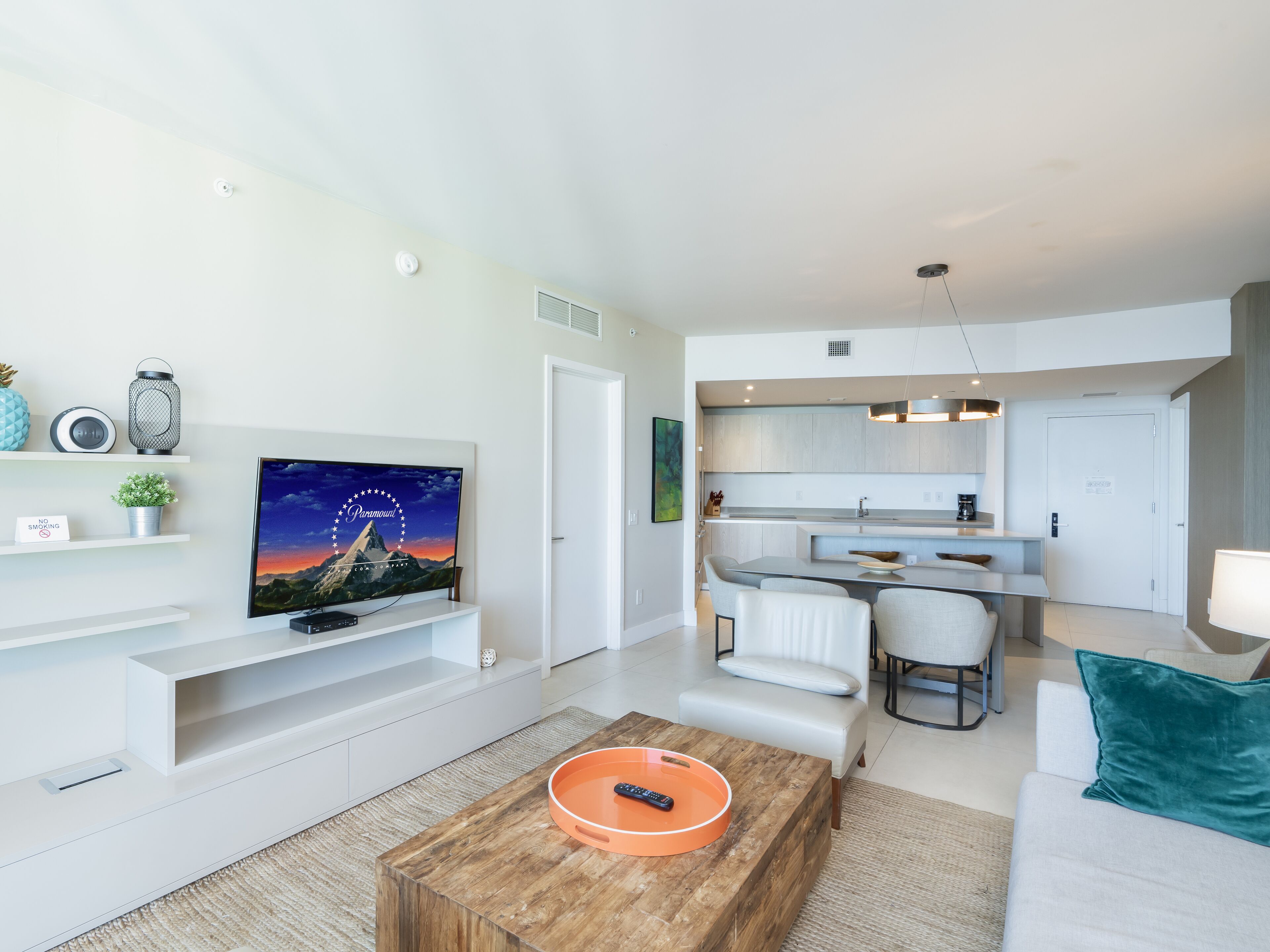 Ein modernes Wohnzimmer mit Flachbildfernseher, Couchtisch und Sofa.