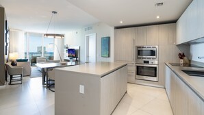 Una cocina moderna con una isla central, electrodomésticos integrados y un comedor con vistas.