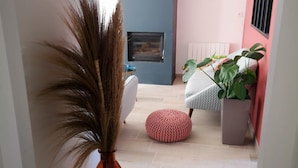 A hallway with a fireplace, a potted plant, and a decorative sign. - House 200m from the beach (Noirmoutier-en-l'Île)