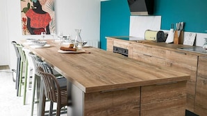 A modern kitchen with a wooden island, bar stools, and pendant lighting. - House 200m from the beach (Noirmoutier-en-l'Île)