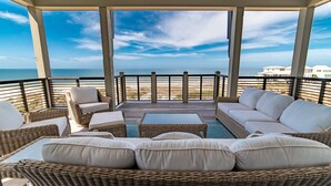 A covered outdoor seating area with wicker furniture and a view of the ocean. - Luxury beach-front home, gourmet kitchen, private pool, gated community, gear (Port Saint Joe)