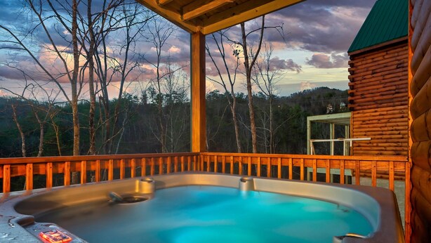 A hot tub on a wooden deck with a view of trees and a cloudy sky. - Best Location 5BR Sleeps 16 (Pigeon Forge)